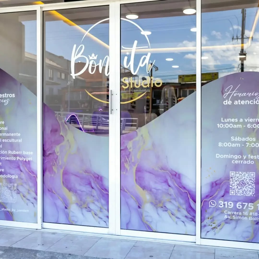 Vitrina de Bonita Studio con vinilo lila, lista de servicios y horario de atención