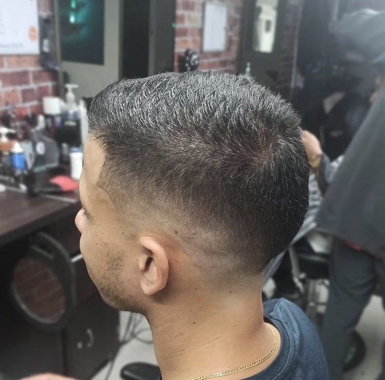 Cliente de perfil con corte corto y degradado bajo a los lados